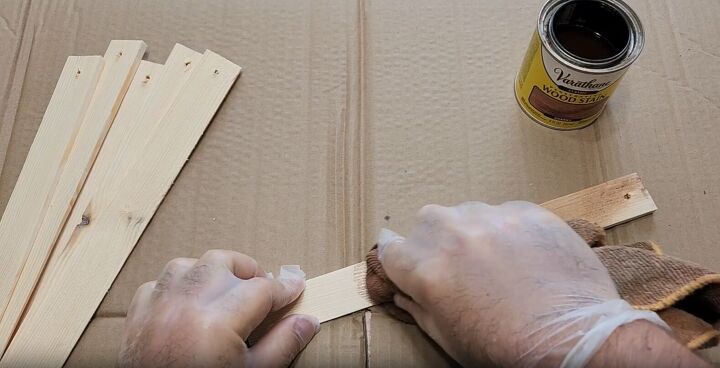Using a towel to apply stain to a wood shim