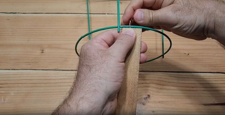 Shim being attached to the tomato cage with copper wire