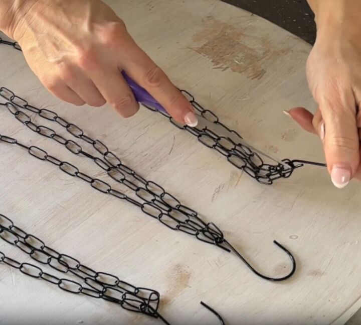 Using a screwdriver to loosen the hooks of the chains