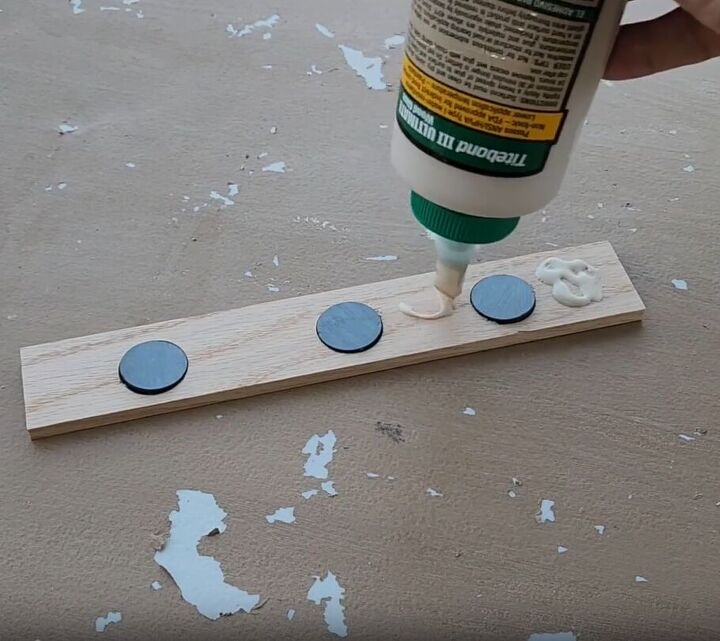 Place magnets in the holes and apply glue to the wood