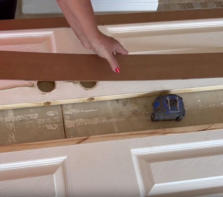 Applying construction adhesive to secure beadboard onto the door
