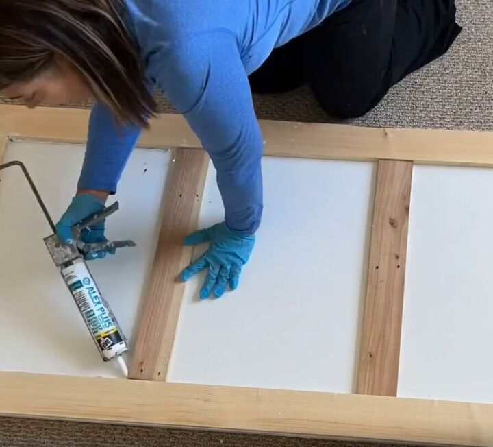 Applying caulk to smooth and seal gaps on the door