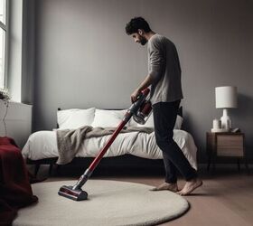 Man vacuuming bedroom carpet