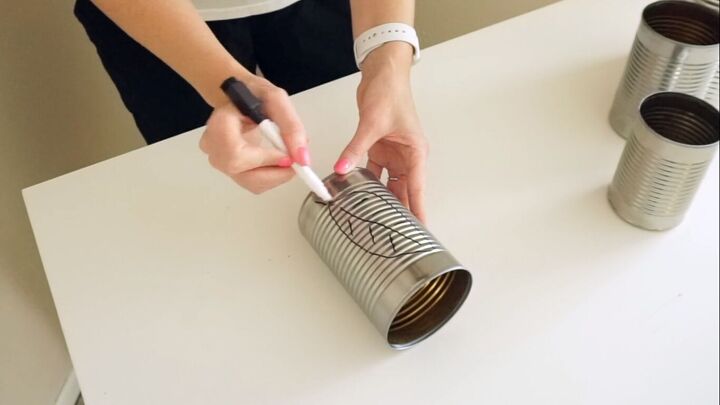 Drawing a leaf design on the tin can