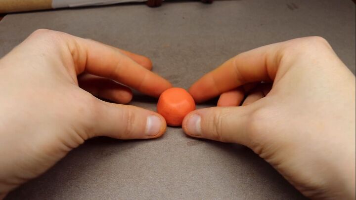 Making a pumpkin out of orange clay