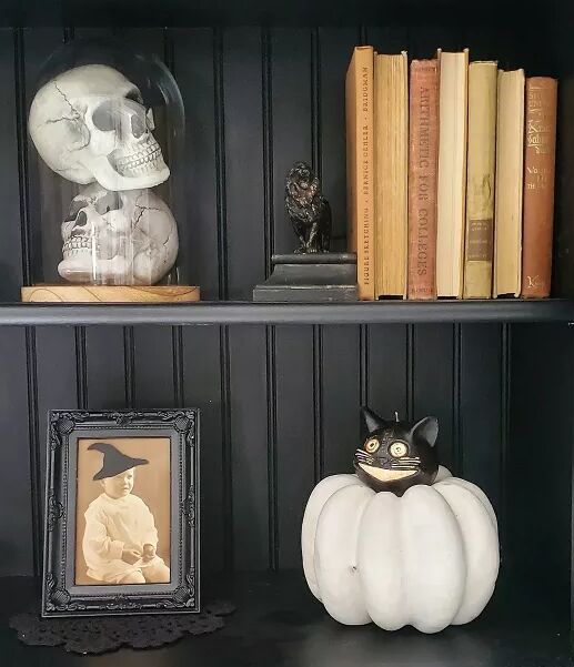 Halloween decor including a vintage portrait with witch hat