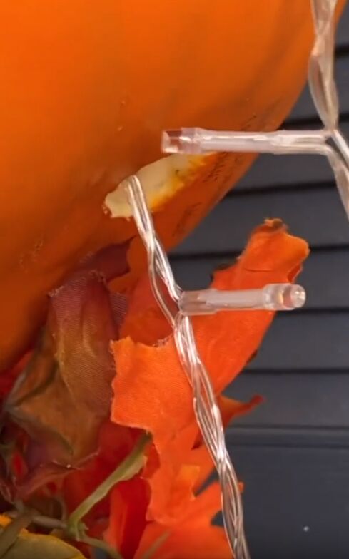 String fairy lights through the holes in the pumpkin