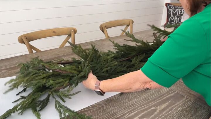Placing a Christmas tree garland on a paper table runner