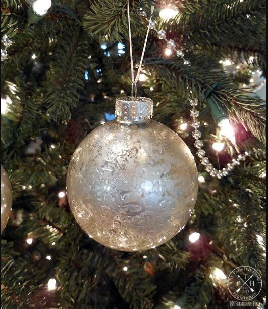 Mercury glass ornament hanging on a tree