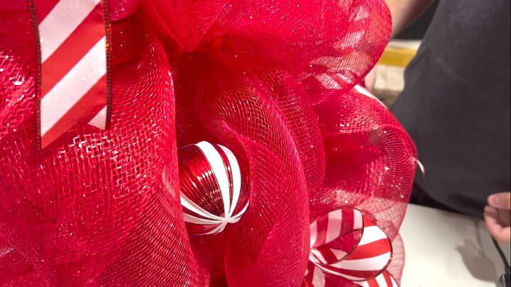 Adding ornaments to the tomato cage Christmas tree