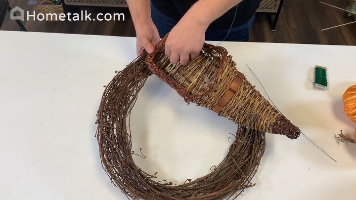 Attaching the cornucopia to the wreath with floral wire