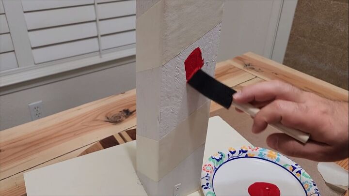 Applying red paint to the post