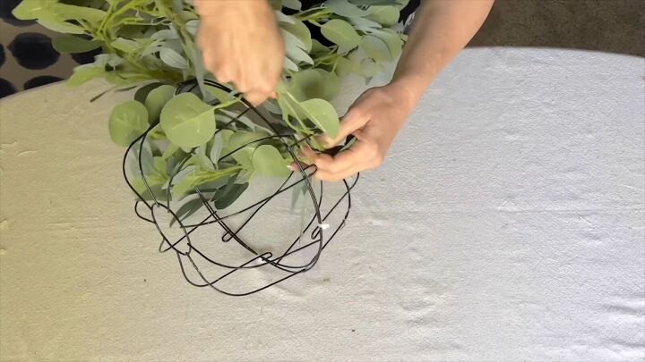 Eucalyptus garland being wrapped around wire globe