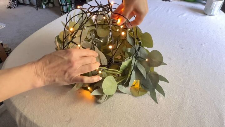 Wrapping fairy lights around pumpkin basket