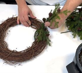 Gluing the pine stems to the grapevine wreath