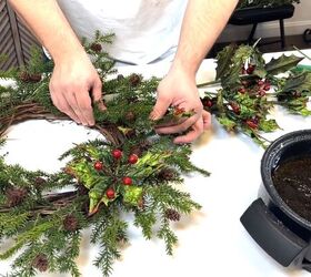 Adding holly stems to the wreath