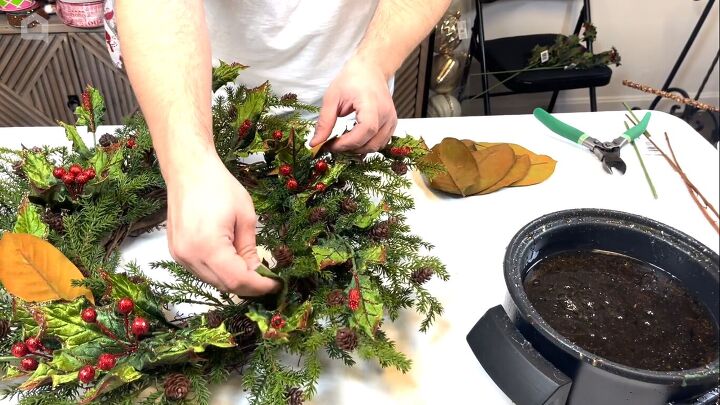 Adding magnolia leaves to the wreath