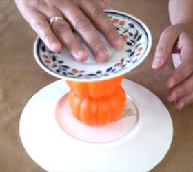 Connecting two thrift store plates with foam pumpkins to create a DIY cake stand