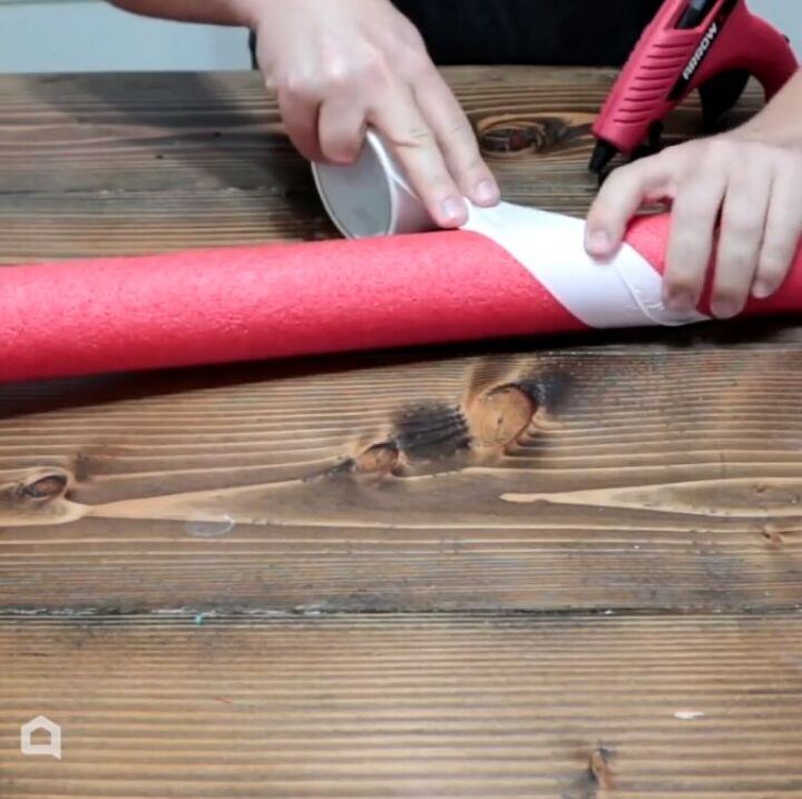 Wrapping white duct tape around a red pool noodle