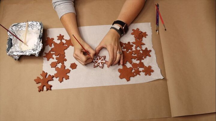 Painting frosting onto the gingerbread snowflakes