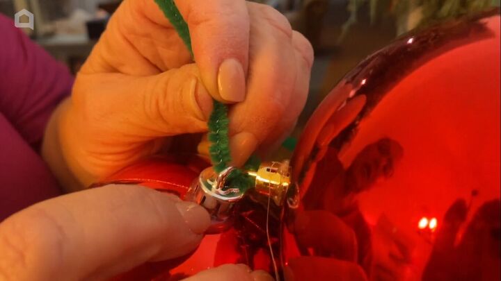 Threading a pipe cleaner through the ornaments