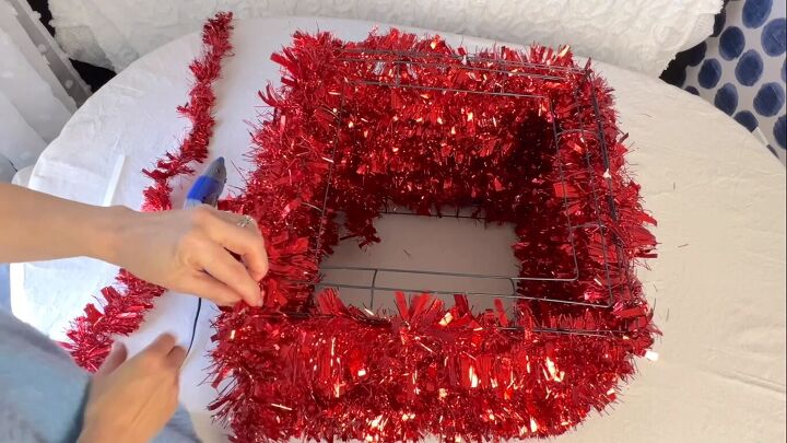 Covering the top of the gift box with tinsel garland