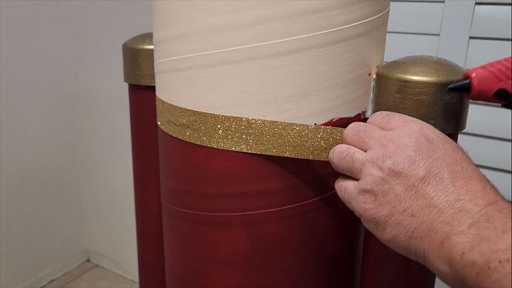 Gluing gold trim to cover the paint lines