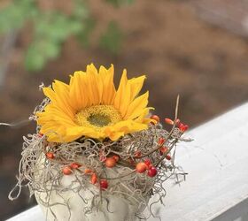 cmo hacer fciles arreglos florales de calabaza diy, Un arreglo floral de calabaza girasol colocado en la barandilla de un porche