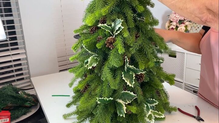 Adding holly picks to the topiary