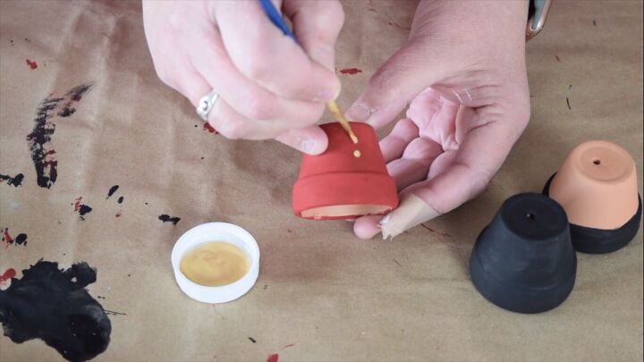 Painting gold details on the terracotta pots