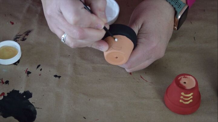 Painting a face on the terracotta pot