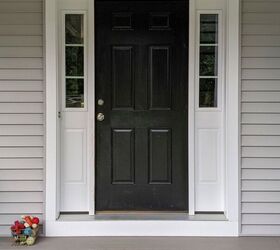 el color de puerta de entrada que nunca supe que siempre quise para mi casa gris, Porche delantero de una casa gris con una puerta negra ara ada y un conjunto de juguetes para perros a su lado