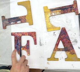 cmo decoupage letras de madera para manualidades de otoo, Usando Mod Podge Spray en brillo para sellar las letras de madera decoupaged