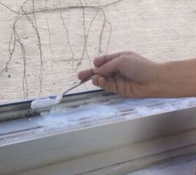 pour vinegar into your windowsill for an easy cleaning hack, Spooning baking soda onto the dirty window tracks