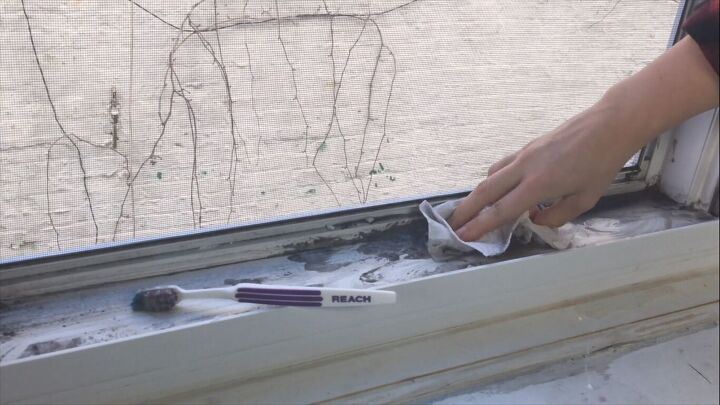 pour vinegar into your windowsill for an easy cleaning hack, Soaking up the mess with a paper towel