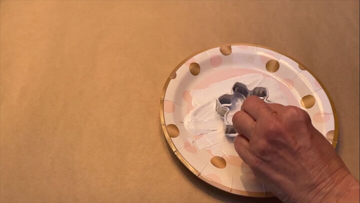 Dipping the cookie cutters in paint