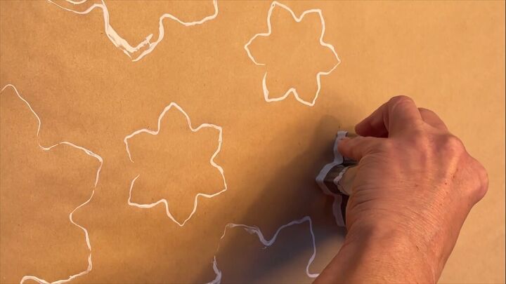 Stamping snowflake shapes on the wrapping paper