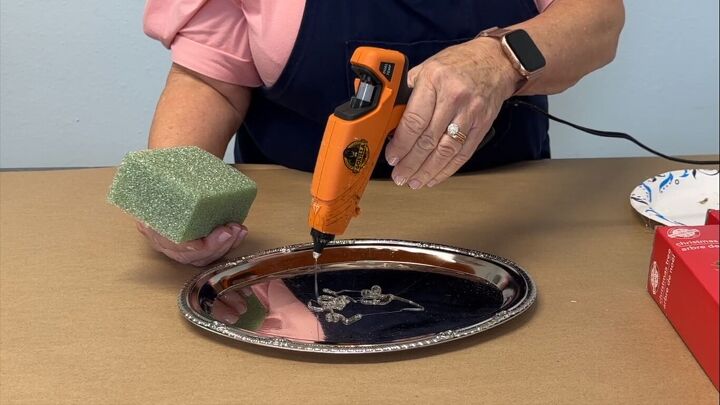 Applying hot glue to a tray