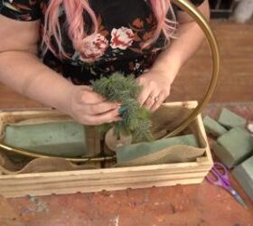 Placing mini Christmas trees inside the crate