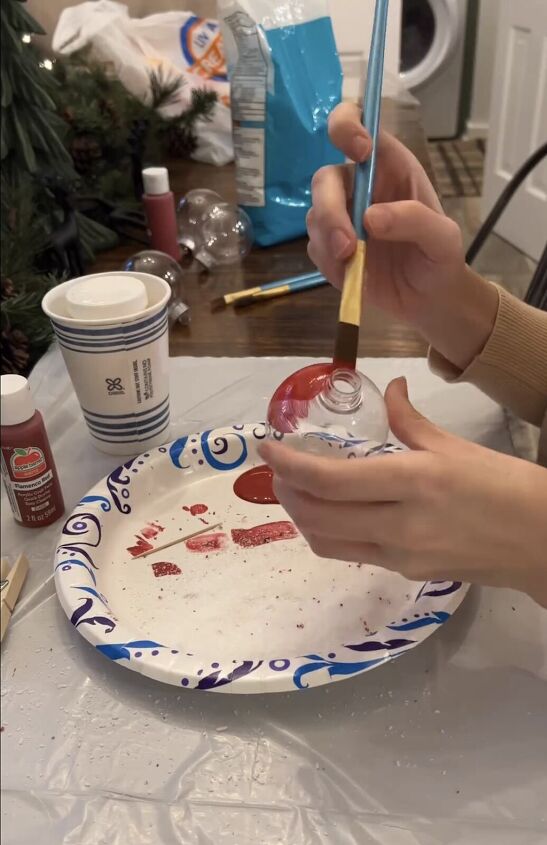 Applying red paint to the ornament