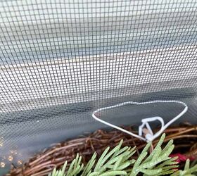She slides a twist tie through her window screen to achieve this idyllic Christmas decor idea