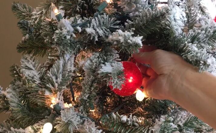 how to decorate a christmas tree, Tucking ornaments into the tree