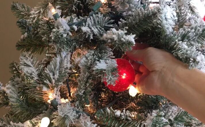 how to decorate a christmas tree, Tucking ornaments into the tree