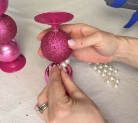 Gluing faux pearls between the ornaments