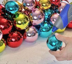 idea de centro de mesa diy con bolas de navidad, Pegado en caliente de adornos para un centro de mesa navide o