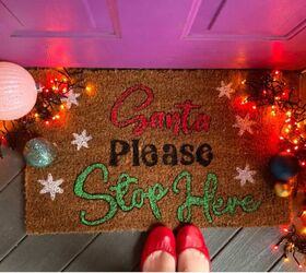 DIY doormat on a front porch with Christmas lights and ornaments