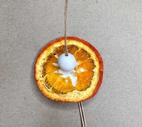 13 ideas de bricolaje para hacer adornos con naranjas secas, Rodaja de naranja pegada encima del disco de madera con una cuenta de madera pegada encima