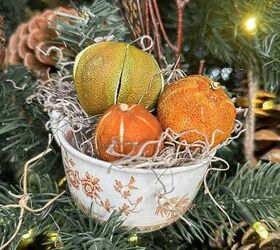 13 ideas de bricolaje para hacer adornos con naranjas secas, Naranjas secas dispuestas en una taza de t con musgo colgando del rbol de Navidad