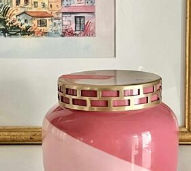 cmo limpiar y reutilizar tarros de velas una gua fcil, Un tarro de velas rosa en una estanter a delante de unas obras de arte