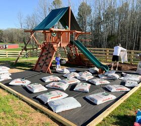 tutorial de cenefa para parque infantil fcil de hacer, dos hombres esparciendo bolsas de pepitas de pino en el interior del borde de parque infantil f cil de hacer alrededor de un columpio